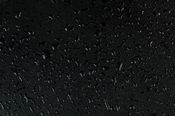 water drops on flat black rubber surface macro background