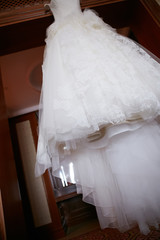 White Wedding dress hanging on a shoulders