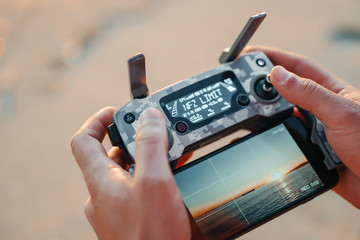 Young man are holding his drone controller in army skin. © Nataly