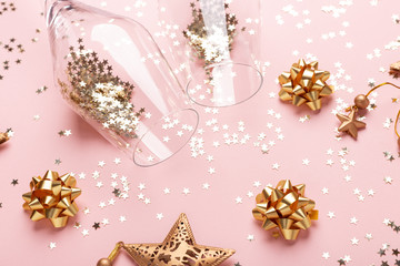 Fototapeta na wymiar Christmas flat lay. Champagne glasses and gold decoration on pink background - Image