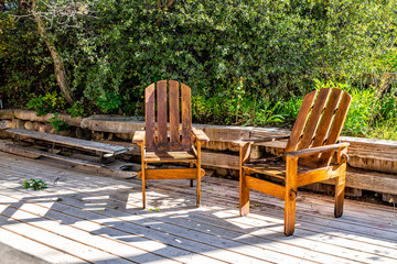 Two empty wooden chairs on deck balcony terrace in garden outside in Colorado summer with nobody