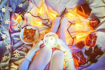 Winter holidays Flatlay with woman's legs, cocoa with marshmallow, Christmas gifts and garland