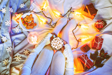 Winter holidays Flatlay with woman's legs, cocoa with marshmallow, Christmas gifts and garland