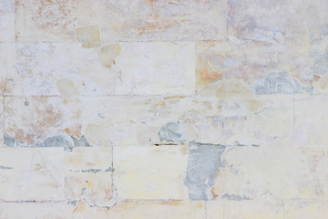Wall made of stone blocks carelessly painted in white