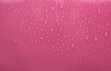 Water drops on pink background, top view