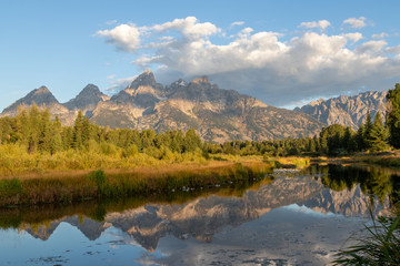 A view of the Grand Teton mountains at sunrise with a reflection in the Snake river from Schwabacher