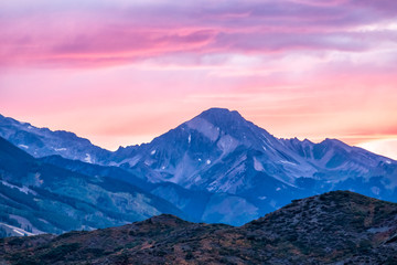 Naklejka na ściany i meble Aspen, Colorado rocky mountains view and colorful purple pink blue sunset twilight with Snowmass mountain peak ridge closeup