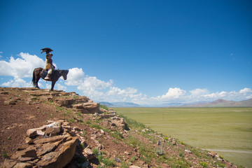 Kazakh eagle hunter on his horse in altai mountains, mongolia
