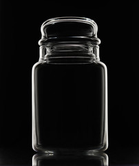 White silhouette of empty glass jar on a black background