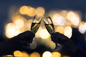 Cheers and celebration with champagne alcoholic drinks and beautiful golden city lights.  © kieferpix