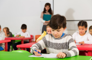 Schoolboy writing at lessons