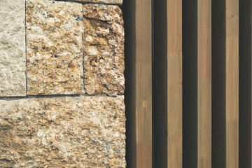 Building facade with ancient stone blocks and modern vertical wooden planks