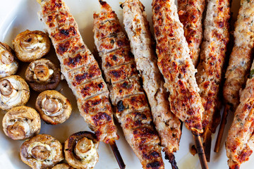 kebab of meat on skewers close-up, grilled mushrooms