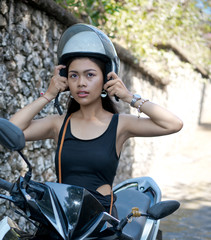 Fototapeta premium Asian girl; in a black dress on a scooter. Beautiful Balinese women lifestyle portrait