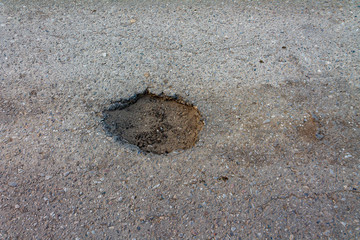 large pit on the road filled with water, the concept of bad broken roads, maintenance and repair of the road surface