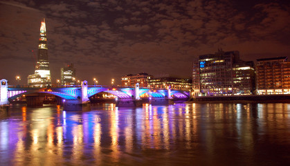 London, UK - August 6th 2012: A night time view of the South Bank with the Shard visible blurred in the background