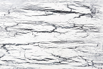 Close up of black and white crackled paint texture on wooden background. 