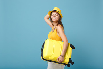 Traveler tourist woman in yellow casual clothes, hat with suitcase photo camera isolated on blue background. Female passenger traveling abroad to travel on weekends getaway. Air flight journey concept