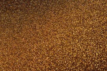 Shining sparkly glittery festive blurred golden texture for background. New year celebration. Copy space. Abstract glamour bright backdrop.