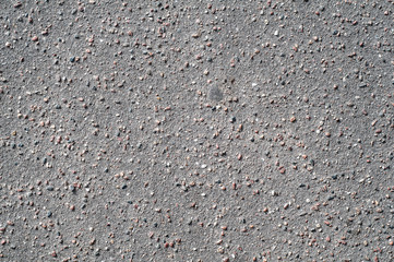 The texture of the background of stone black gray asphalt road with small pebbles.