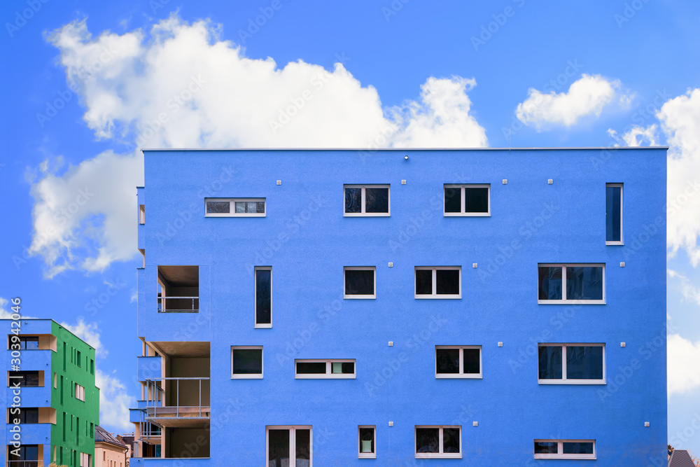 Wall mural Colorful Modern residential apartment and flat building exterior in Salzburg, Austria. New luxury house and home complex of blue color. City Real estate property and condo architecture. Blue sky