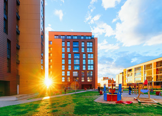 Apartment house and home building complex concept. Street with a children playground. With sun light