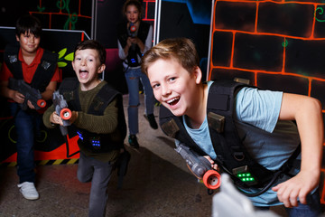 boy aiming laser gun at other players during lasertag game © JackF