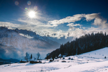 Winter postcard of cottage in the mountains at sunrise. Christmas concept.