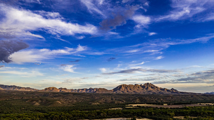 Sunset, aerial landscapes of Santa Rita Mountains from above Tubac, Arizona with warm , golden plains, purple mountains, blue sky with colorful clouds on a Fall day 