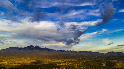 Fototapeta na wymiar Sunset, aerial landscapes of Santa Rita Mountains from above Tubac, Arizona with warm , golden plains, purple mountains, blue sky with colorful clouds on a Fall day 