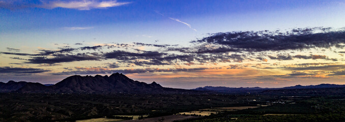 Sunset, aerial landscapes of Santa Rita Mountains from above Tubac, Arizona with warm , golden plains, purple mountains, blue sky with colorful clouds on a Fall day 