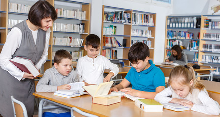 Fototapeta na wymiar School kids studying with female teacher