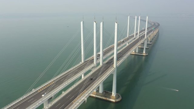 Tilting drone flight over tall section of the massive Jiaozhou Bay Bridge project, a modern highway spanning 25.9 kilometres connecting Qingdao with Huangdao in China