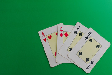 four 4 cards of a poker deck over a green background