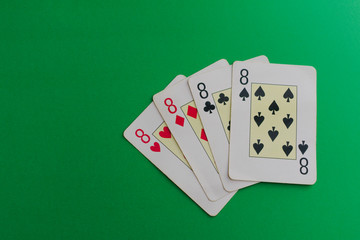 four 8 cards of a poker deck over a green background