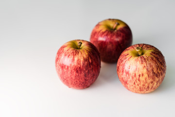 Fresh red yellow striped apples with water droplets on a white glossy kitchen table. Tasty bright juicy fruits. Healthy eating Isolated object