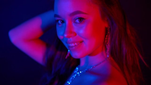 beautiful woman in neon light. Party. Jewerly on her neck. Celebrating