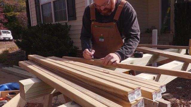 Carpenter measuring and marking boards for cutting
