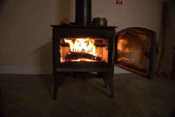 Wood stove burning inside.  Alternative heat source and energy source. Off grid