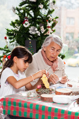 Grandmother teaching her granddaughter how to make christmas Nativity crafts - Real family