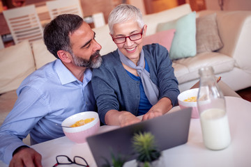 Cheerful couple using laptop