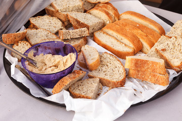 Platter of bowl of hummus with a variety of bread