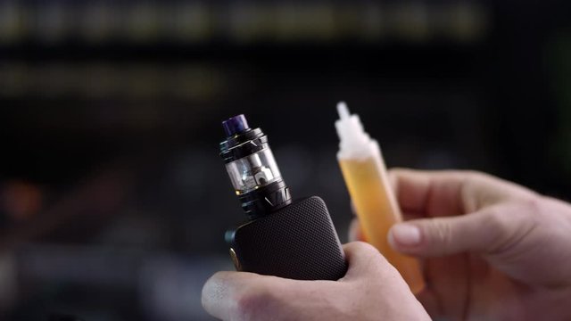 Close-up of vape juice filling up an atomizer on a electronic cigarette