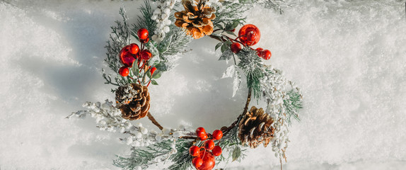 Beautiful christmas wreath frame on fresh white snow. Minimal winter vacation idea. Flat lay top...
