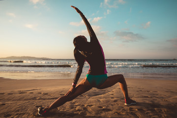 Fototapeta na wymiar Woman surfer warming up on sunset beach