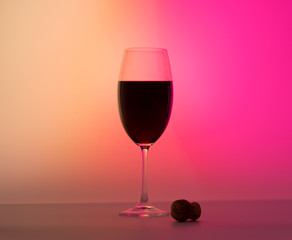 Matte wineglass half red wine half pink half orange background