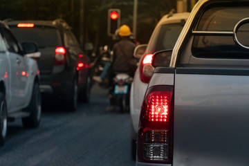 ฺBrake of pick up car on asphalt roads during rush hours for travel or business work. Evening environment. Traffic jam with other car and motorcycle blurred image.