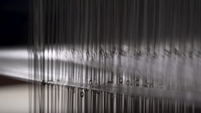 Closeup Of Cotton Thread Being Weaved In A Textile Factory.