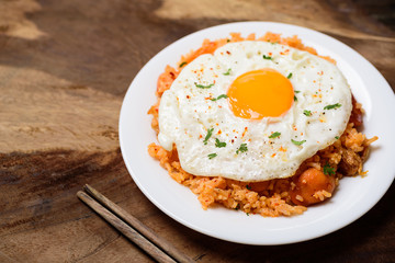 Kimchi fried rice with fried egg on wooden background, Korean food