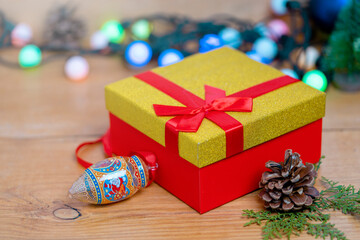 Christmas gift box with christmas balls and cones on a wooden table